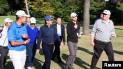 美国总统川普与日本首相安倍晋三和日本职业高尔夫球手松山英树在埼玉县的高尔夫球俱乐部打高尔夫。