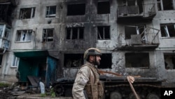 Міністр оборони Росії Сергій Шойгу доповів російський наступ поблизу Часового Яру, Авдіївки та Донецька. На фото український військовий проходить повз пошкоджений житловий будинок у Часовому Яру в Донецькій області, Україна, 9 травня 2023 р. (Ірина Рибакова через AP)