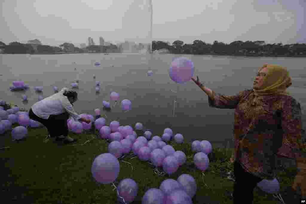 Phụ nữ Malaysia thả bong bóng tượng trưng cho những lời cầu nguyện của cho 239 người trên chuyến bay bị mất tích tại một công viên ở Kuala Lumpur, ngày 30/3/2014.