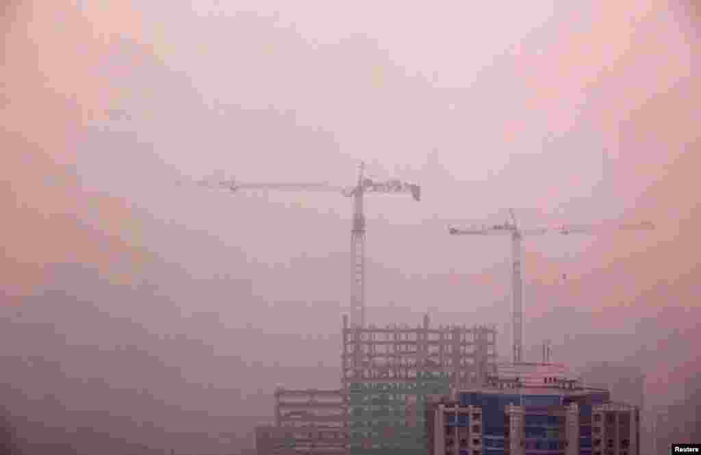 Cần cẩu trên đỉnh một tòa nhà dân cư được xây dựng ở trung tâm Bắc Kinh, ngày 18 tháng 4 năm 2012.