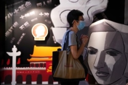 香港支联会负责营运的六四纪念馆，一名游客在一块刻有民主女神像的板子旁边祈祷
