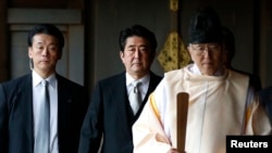 日本首相安倍晋三在神道祭司的引领下参拜东京靖国神社。