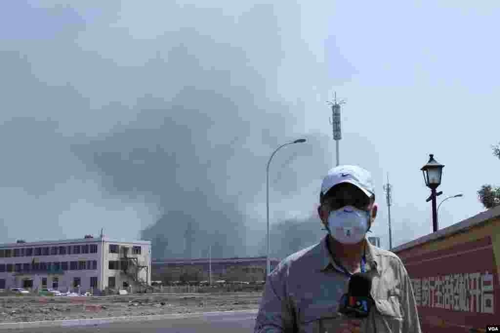 天津爆炸事故现场,核心爆炸区周围多座居民楼窗户被震碎,高速公路桥梁受损,多辆大货车被炸翻,小汽车起火或被砸,多名当地居民仍逗留在事故现场。(美国之音记者东方拍摄)