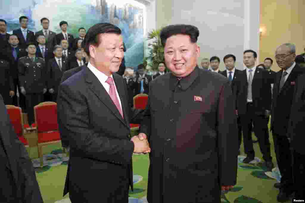 朝鲜领导人金正恩同中共政治局常委刘云山在平壤握手,刘云山这个访问是为了庆祝朝鲜"劳动党"建党70周年(2015年10月10日)。