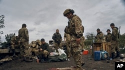 Фото: український військовий соїть на російському прапорі в Ізюмі, 13 вересня 2022 року.(AP Photo/Kostiantyn Liberov)