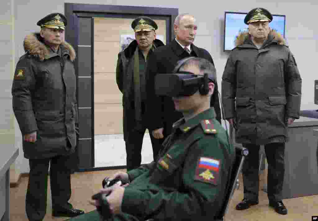 Russian President Vladimir Putin, second right, Russian Defence Minister Sergei Shoigu, second left, and Russian Strategic Missile Troops Commander, Col. Gen. Sergei Karakayev, right, visit the Military Academy of Strategic Rocket Troops after Peter the Great in Balashikha, outside Moscow, Russia.