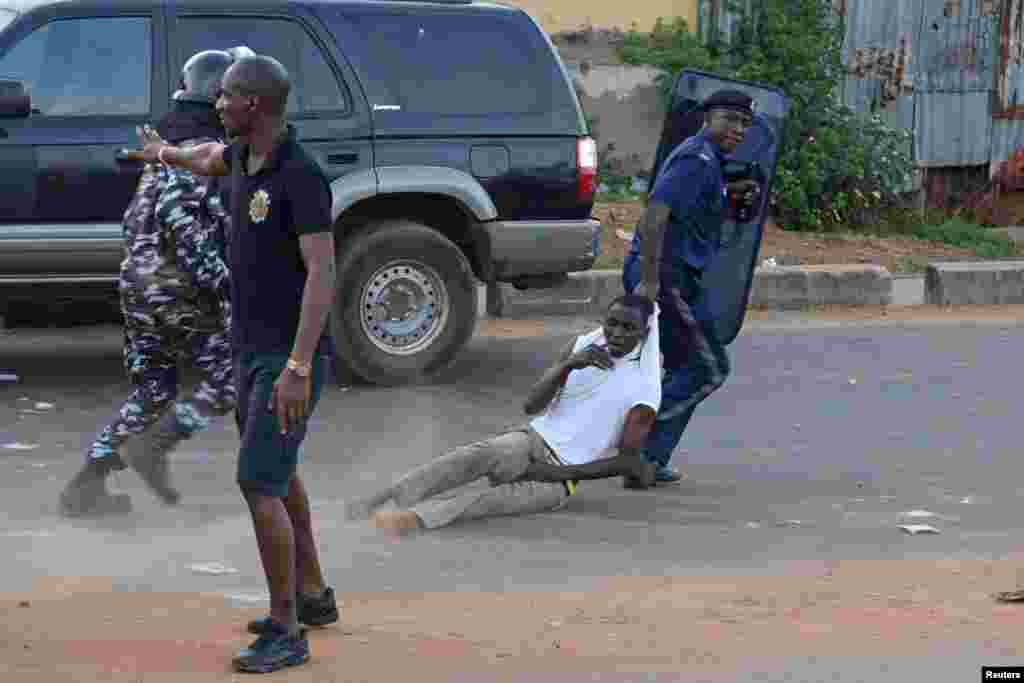 An anti-riot policeman drags away a supporter of Sierra Leone People's Party (SLPP) during a protest against the police attempting to search the offices of Julius Maada Bio, the presidential candidate for (SLPP) in Freetown, Sierra Leone, March 7, 2018.
