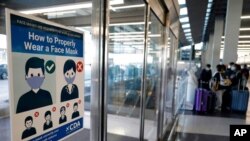 资料照片：芝加哥国际机场入境地区要求旅客佩戴口罩的告示（2020年7月2日）