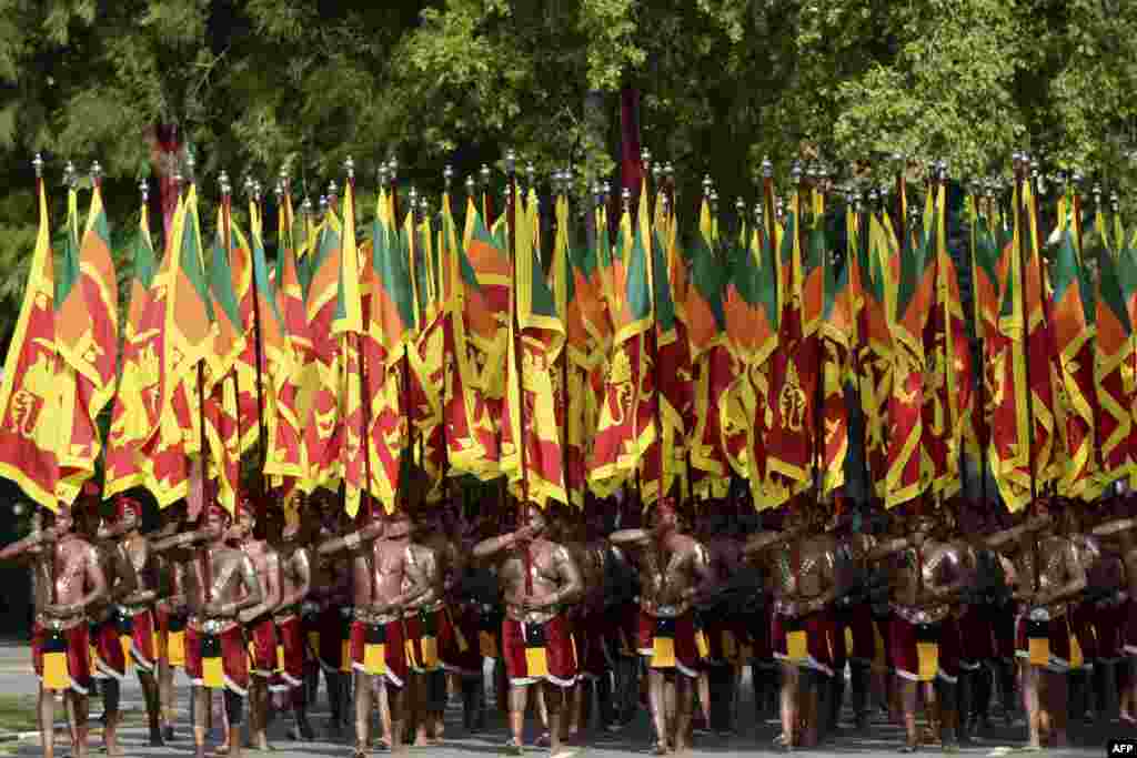 Sri Lankan military personnel with the army cultural troupe march wearing traditional dresses and holding national flags during the country's 73rd Independence Day celebrations in Colombo.