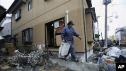 日本福岛县一位居民海啸过后在清理自家的院落