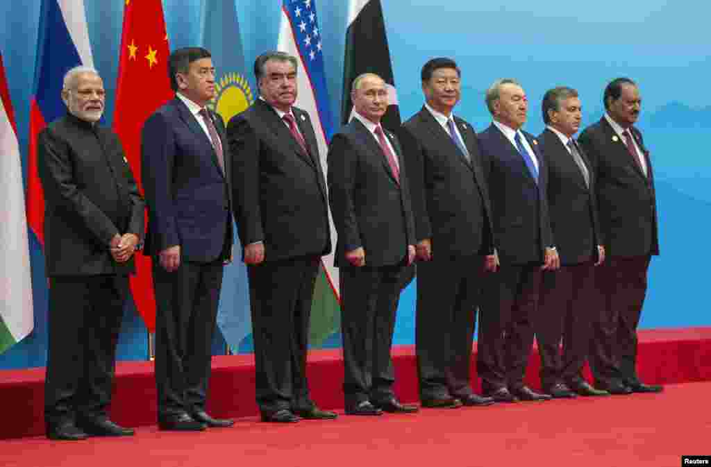 在中国山东省举行的上海合作组织成员国首脑会议合影。左起:印度共和国总理莫迪,吉尔吉斯斯坦共和国总统热恩别科夫,塔吉克斯坦共和国总统拉赫蒙,俄罗斯总统普京,中华人民共和国主席习近平,哈萨克斯坦共和国总统纳扎尔巴耶夫 ,乌兹别克斯坦共和国总统米尔济约耶夫,巴基斯坦共和国总统侯赛因(2018年6月10日)。 其中普京和纳扎尔巴耶夫都已经执政多年,本网的江泽民图集里有他们和江泽民的合影。如今他们继续掌权。