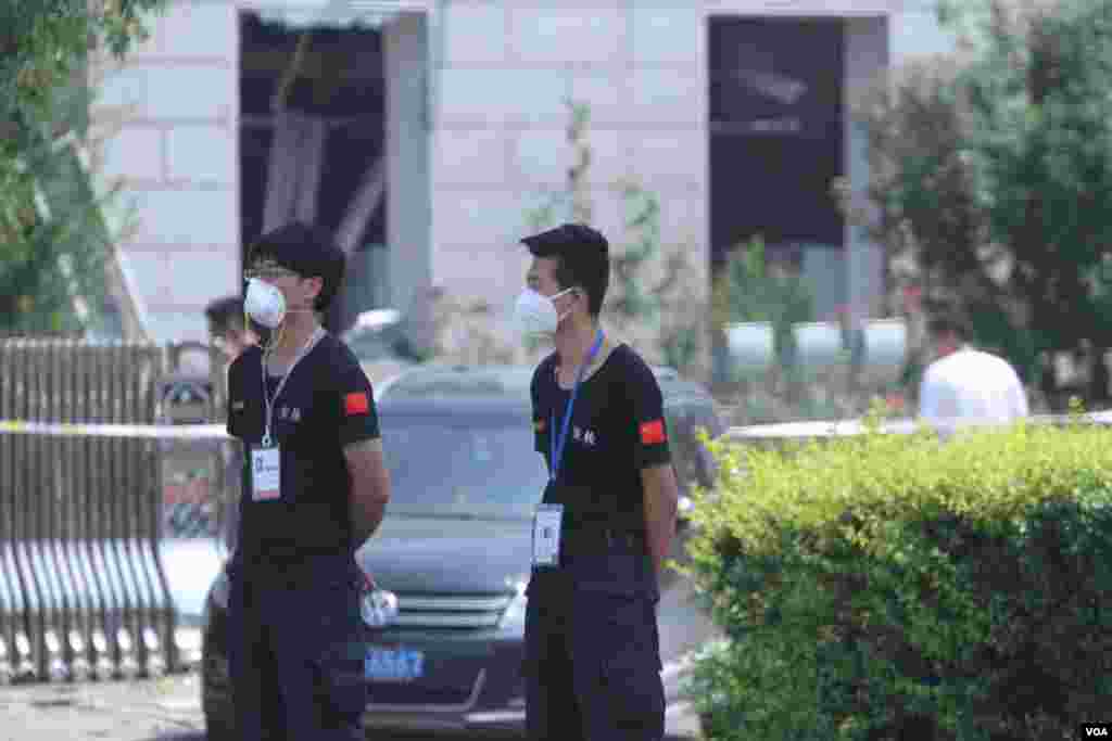 天津爆炸事故现场,核心爆炸区周围多座居民楼窗户被震碎,高速公路桥梁受损,多辆大货车被炸翻,小汽车起火或被砸,多名当地居民仍逗留在事故现场。(美国之音记者东方拍摄)