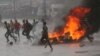 People run at a protest as barricades burn in Harare, Zimbabwe, Jan. 14, 2019.