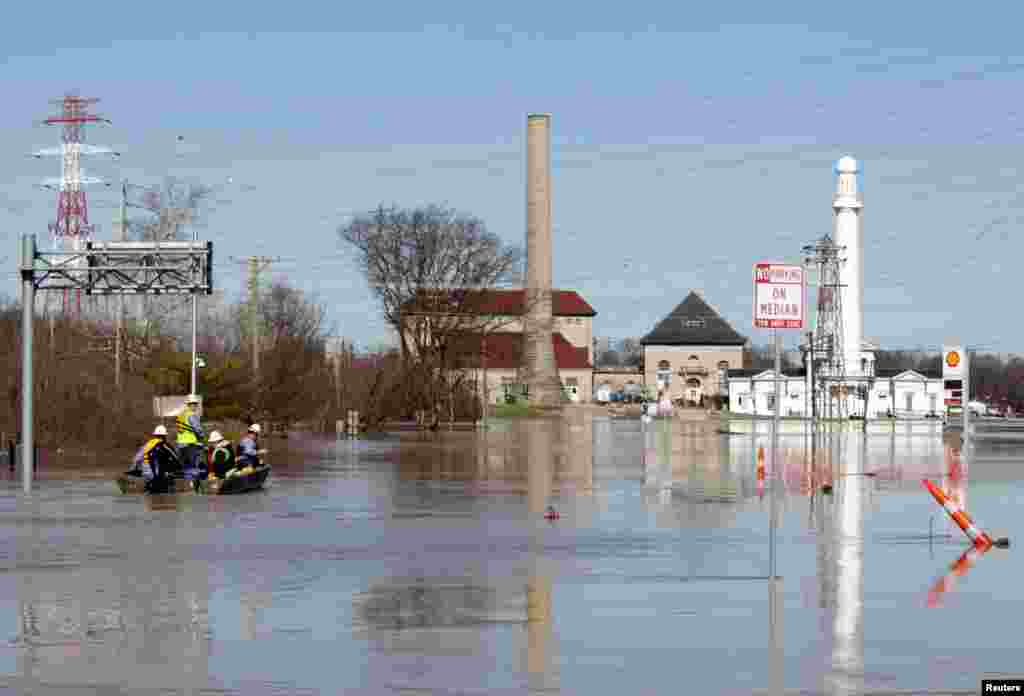 Employees of Louisville Gas & Electric make their way to River Road to turn off power to companies along the Ohio River after it flooded Louisville, Kentucky, Feb. 26, 2018.