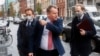 Britain's chief negotiator David Frost, center, removes his face mask to talk to the media as he arrives for Brexit talks with EU chief negotiator Michel Barnier in Brussels, Belgium, Nov. 16, 2020.