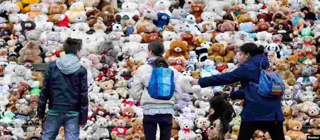 School students set up 740 teddy bears in front at of the concert hall Konzerthaus during an event of the World Vision Organization to make aware of 740000 Syrian refugee children who can't attend the school, in Berlin, Germany.