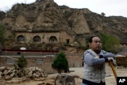2012年10月18日，一个农民站在习近平青年时期在中国陕西省梁家河住过的窑洞附近。
