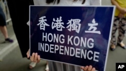 在香港警察总部前抗议的民众手持香港独立的标语。（2018年9月25日）
