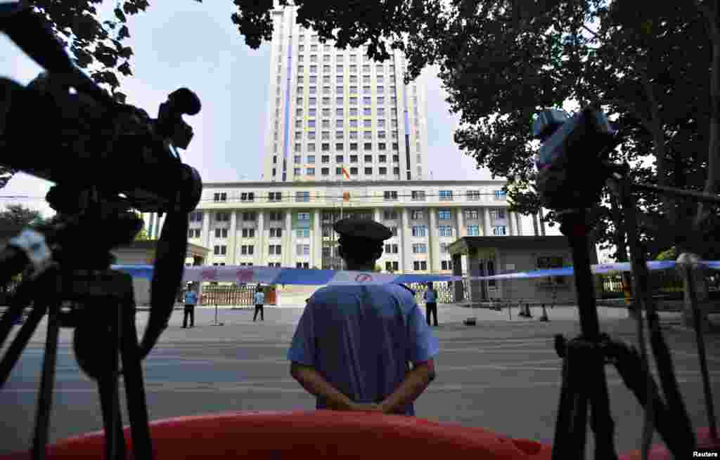 8月26日,一名警察守卫在济南中级法院的入口处。