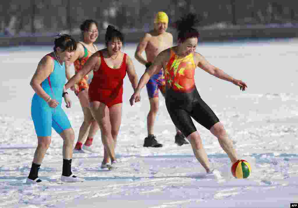 Chinese women run with a ball on a snow covered field in Shenyang in China's northeastern Liaoning province during International Women's Day.