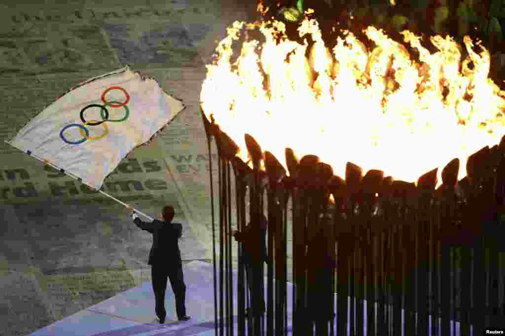Thị trưởng thành phố Rio de Janeiro Eduardo Paes vẫy cờ Olympic nhận được từ Chủ tịch Ủy ban Thế vận hội Jacques Rogge tại Lễ bế mạc Olympic London 2012, ngày 12/8/2012.