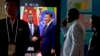 在北京举行中非合作论谈期间，非洲代表团成员走过正在播放中国国家主席习近平与埃塞俄比亚总理艾哈迈德握手的视频画面。（2018年9月3日）