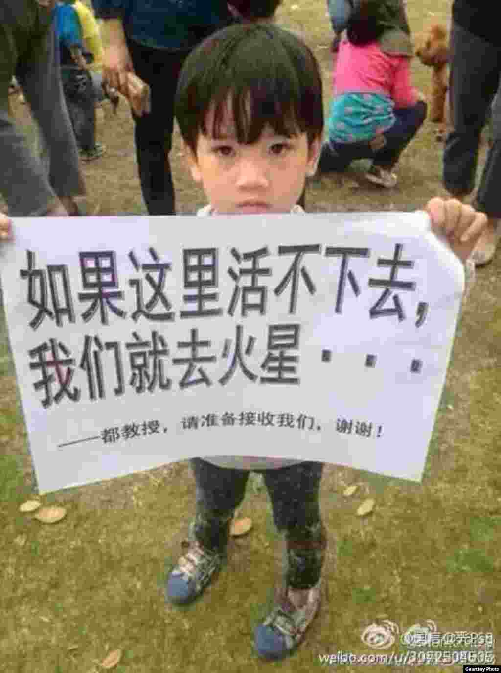 一名参加茂名抗议的儿童举着标语牌:如果这里活不下去,我们就去火星……