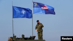 Прапори НАТО та бойової групи посиленої передової присутності НАТО майорять під час військових навчань Crystal Arrow 2021 в Адажі, Латвія, 26 березня 2021 р. REUTERS/Ints Kalnins