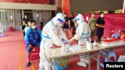 中国云南边境城市瑞丽民众在排队接受新冠病毒核酸检测。（2021年7月5日）