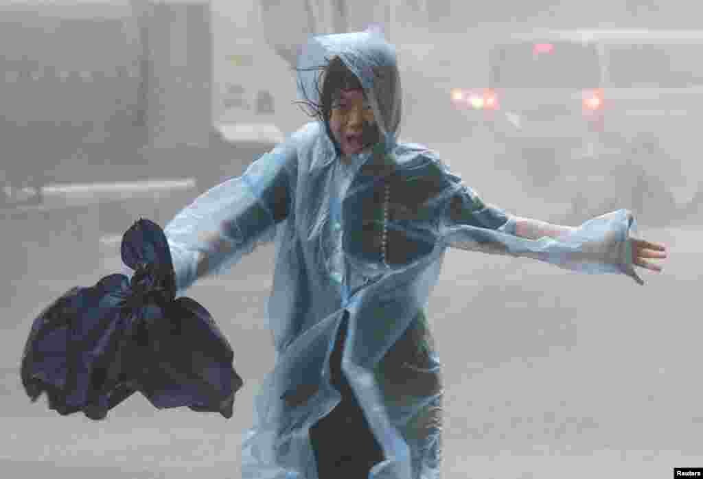2018年9月16日,在中国深圳,台风山竹临近,一名女子在暴雨中奔跑。强台风“山竹”严重影响广东、香港、澳门,登陆时中心风力达14级。广东台山街道成河,水乡变泽国。美国国务卿蓬佩奥表示:“我们惦记那些受台风‘山竹’影响的人并为他们祈祷,同时我们向遇难者的家属及至爱亲朋表示哀悼。”