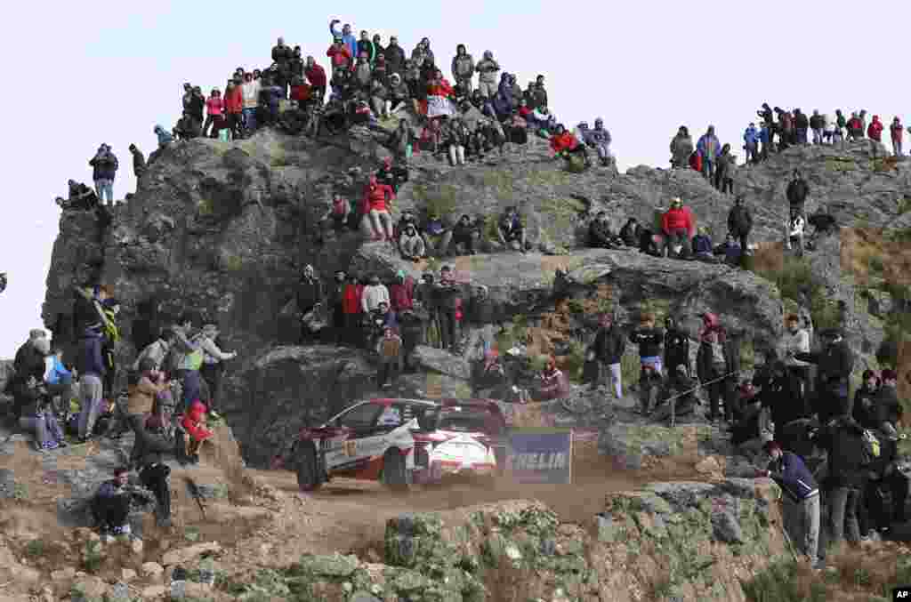 People watch driver Ott Tanak and his co-driver Martin Jarveoja, both from Estonia, race their Toyota Yaris WRC during the FIA World Rally Championship in El Condor, Cordoba, Argentina.