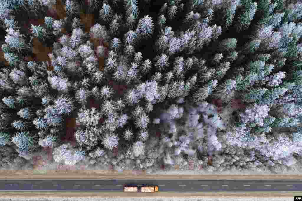 An aerial picture taken with a drone shows a truck driving on a forest road near the village of Krevo, some 100 km north of Minsk.