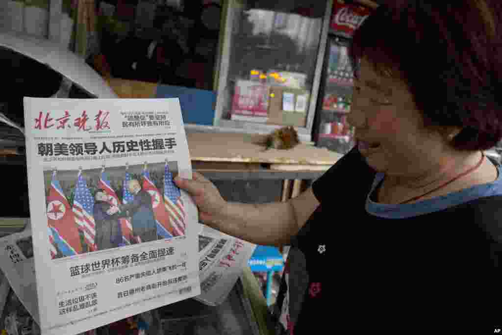 2018年6月12日,北京报摊小贩观看报道美国朝鲜首脑峰会的报纸。中国媒体在标题里把朝鲜放在美国前面。