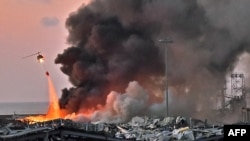 一架直升机在贝鲁特港口爆炸地点上空灭火。(2020年8月4日)
