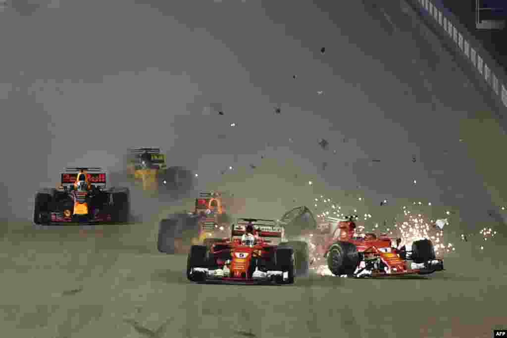 The car of Ferrari's Finnish driver Kimi Raikkonen (R) is seen after a crash as Ferrari's German driver Sebastian Vettel (C) leads during the Formula One Singapore Grand Prix in Singapore, Sept. 17, 2017.