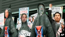 韩国的抗议者于2013年４月１５日金日成的冥诞在首尔举行的反朝鲜的抗议活动中展示已故领导人金正日（右）以及金日成（左）的吊死人像。