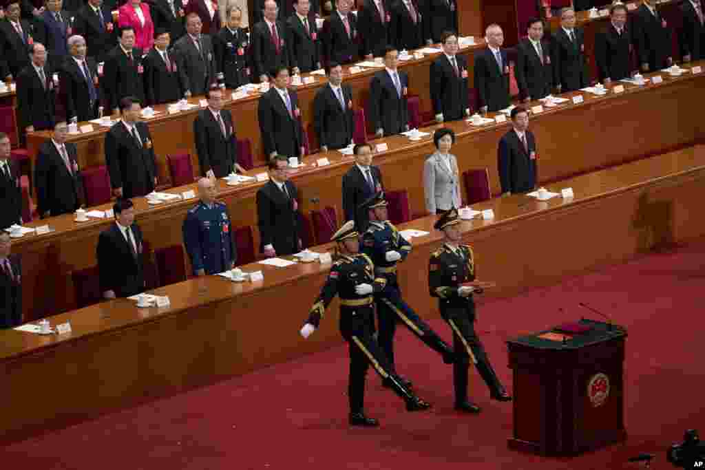 2018年3月17日在中国人民代表大会全体会议上举行的宪法宣誓仪式中,礼兵手捧宪法正步入场,把一大本宪法书送上宣誓台。他们身后第一排座位上,穿军装者为中央军委排名第一的副主席许其亮,女官员为人大副委员长、 中华全国妇女联合会主席沈跃跃。此前, 陆海空三军仪仗兵分两列正步行进至主席台前伫立。