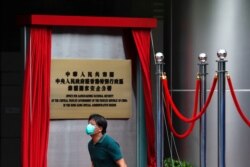 一名男子走过香港一家酒店外北京新设的驻港国安公署的牌子。（2020年7月8日）
