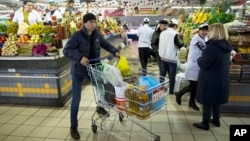 俄罗斯莫斯科，一名男子在一家杂货店推着装有食品的手推车（2015年4月2日）。