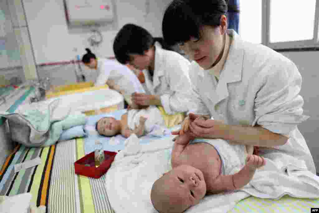 2016年12月15日,在中国西南部重庆市涌泉的婴儿护理中心,护士们按摩婴儿。研究人员在2019年1月表示,去年中国人口数量出现萎缩,这是几十年来首次。有人警告称这是“人口危机”,给中国放缓的经济带来压力。