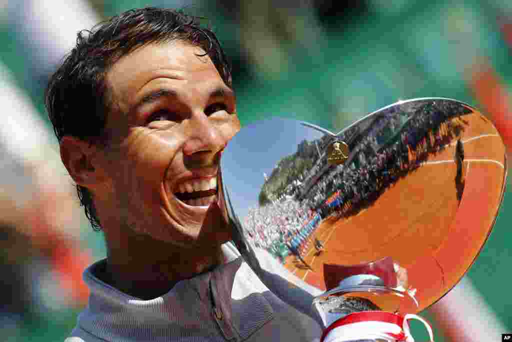 Spain's Rafael Nadal holds the trophy as he celebrates winning the men's singles final match of the Monte Carlo Tennis Masters tournament against Japan's Kei Nishikori in two sets, 6-3, 6-2, in Monaco.