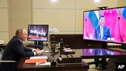 На фото: президент Росії Володимир Путін під час спілкування із президентом Китаю Сі Цзіньпіном