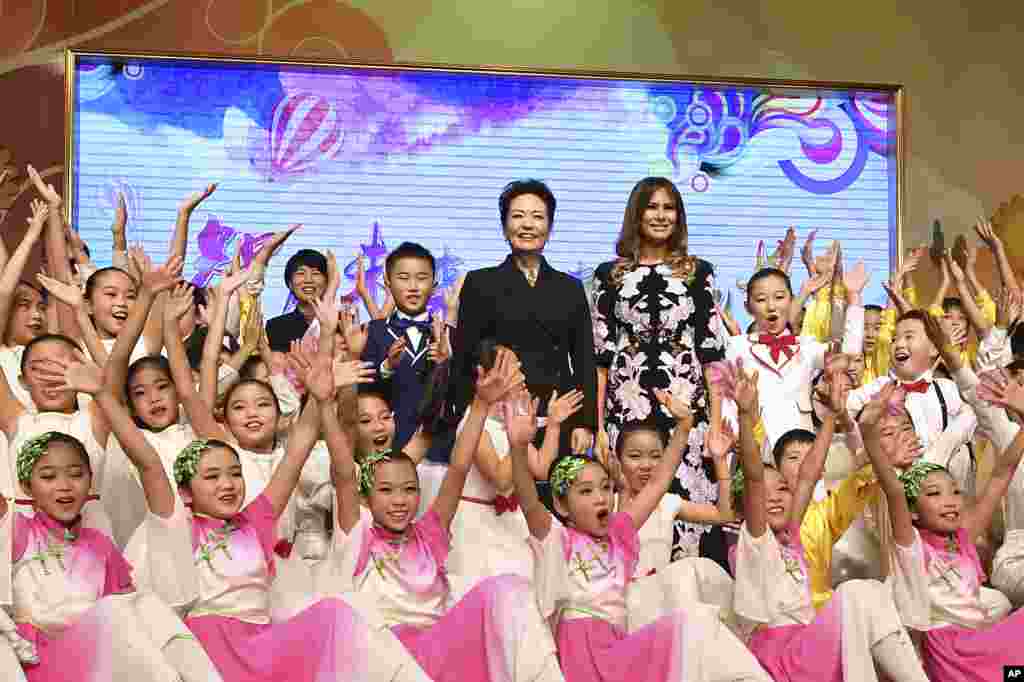 美国第一夫人梅拉尼娅·川普和中国国家主席习近平夫人彭丽媛访问北京板厂小学,观看文艺表演。孩子们围绕在她们身边欢呼(2017年11月9日)。