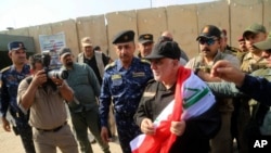 伊拉克总理哈德尔·阿巴迪（Haider al-Abadi）披着国旗，抵达摩苏尔市（2017年7月9日）