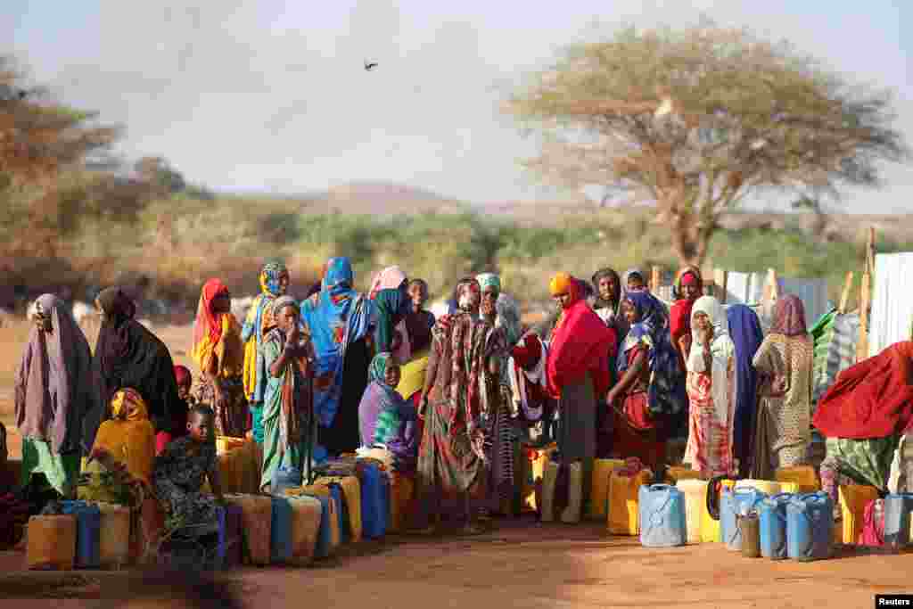 Somali women wait to collect water at the New Kabasa internally displaced camp in the northern Somali town of Dollow, Somalia.