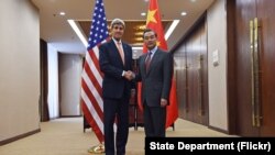 美国国务卿克里(左)在北京与中国外长王毅会谈前握手.(2016年1月27日) 