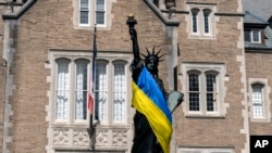 Американські ЗМІ публікують яскраві висловлювання військових, економістів та політичних оглядачів на тлі політичних суперечок у Конгресі США. На фото: прапор України довкола копії Статуї Свободи у Вашингтоні, США. AP Photo/Manuel Balce Ceneta
