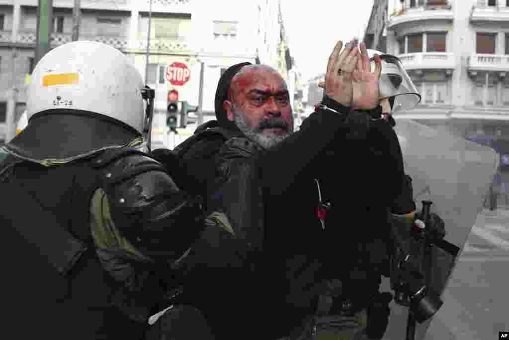Riot policemen detain a protester during a scuffle in Athens, Greece. Protesters from across the country converged on Athens' main square outside parliament to protest a potential Greek compromise in a dispute with neighboring Macedonia over the former Yugoslav Republic's official name.
