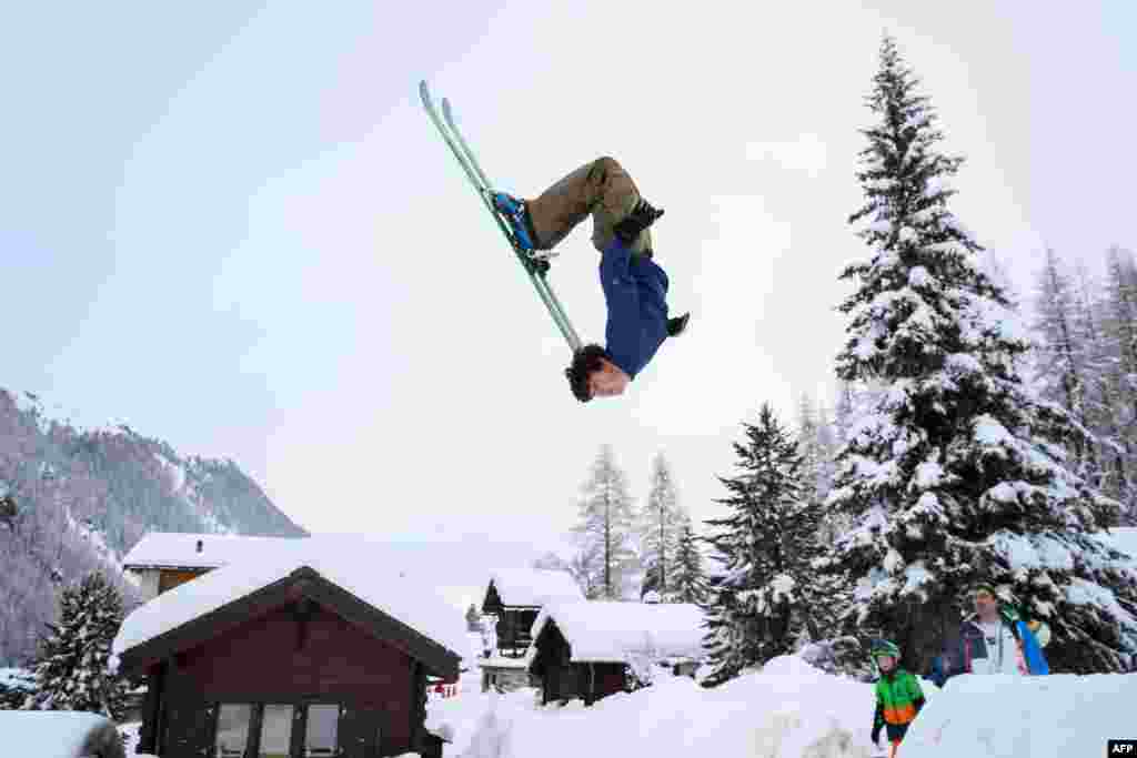 Teenager Luc makes a backflip on skis in the small resort of Zinal, Swiss Alps, after the access road which was cut by heavy snowfall reopened.