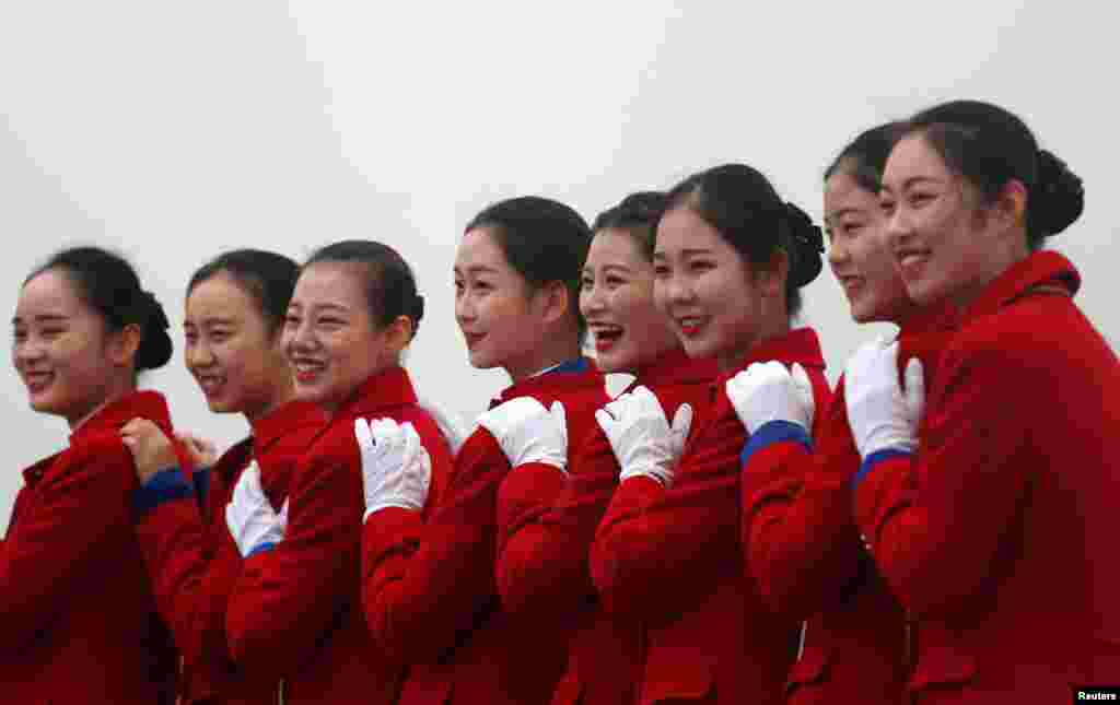 中国共产党第十九次全国代表大会在北京人民大会堂开幕之际,接待员在天安门广场拍照(2017年10月18日)。香港苹果日报说,中共十九大美女接待员成场外亮点。